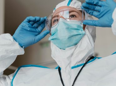 doctor-putting-protective-goggles_23-2148847202 doctor-putting-protective-goggles_23-2148847202